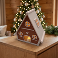 Lebkuchenhäuschen mit LED-Teelicht auf einem Sideboard im weihnachtlichen Chalet-Stil